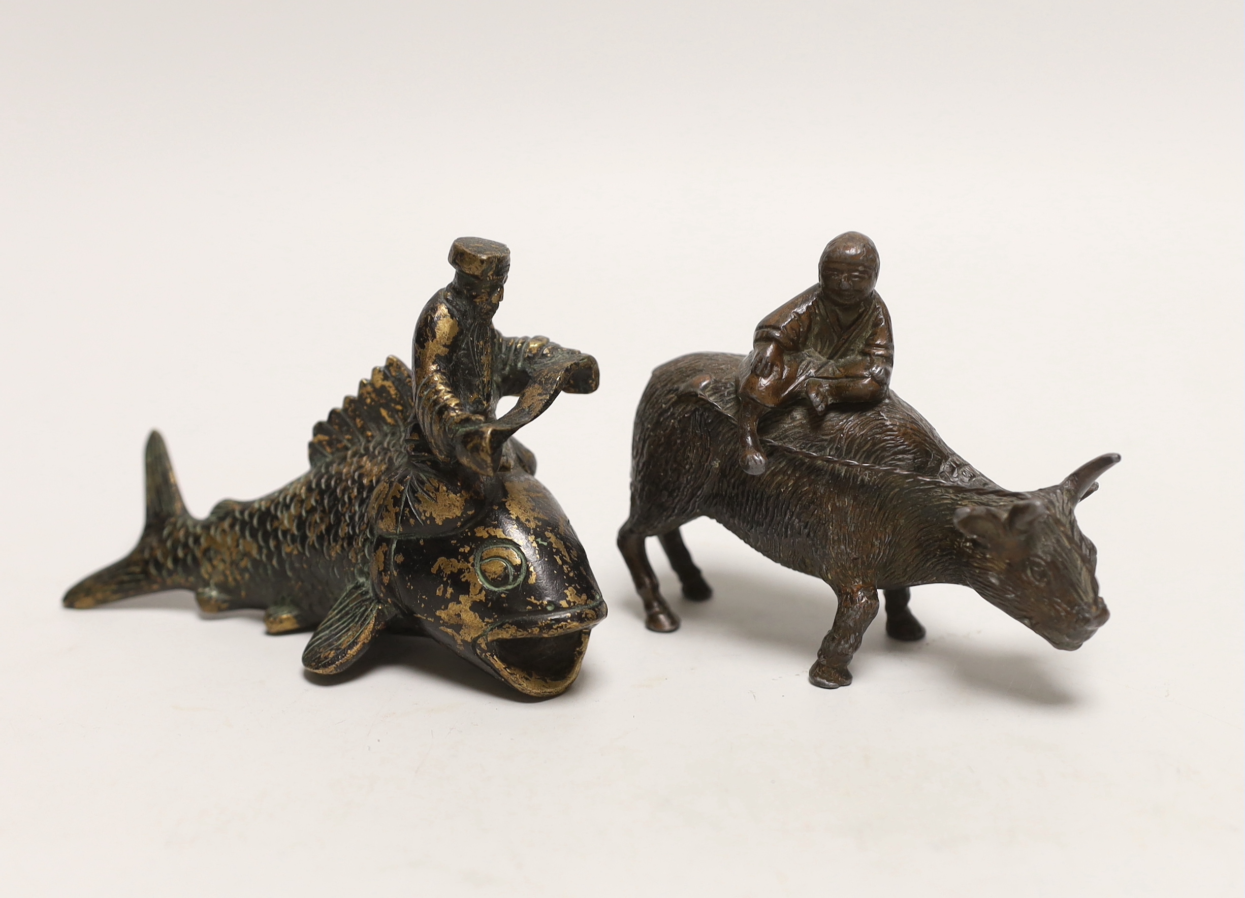 A Chinese parcel gilt metal model of a figure reading a scroll on a fish and one riding a buffalo, tallest 9cm